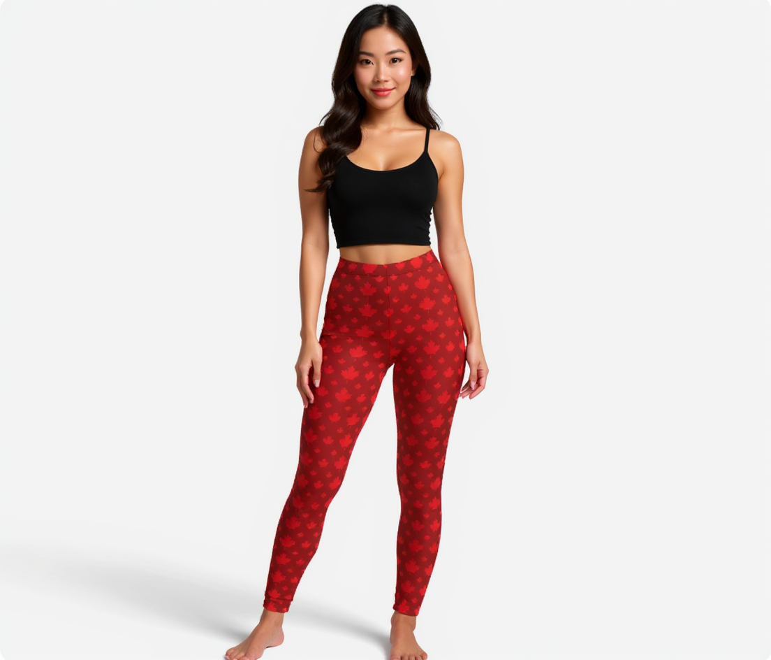 Woman wearing red patterned maple leaves leggings and black crop top on a white background